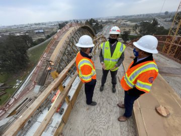 USDOT FRA Deputy Administrator Amit Bose conferring with Authority experts while standing atop the falsework that will help cast one of the concrete arches of the Cedar Viaduct which will carry trains at more than 200 miles per hour over State Route 99, with the structure's other arches behind him.