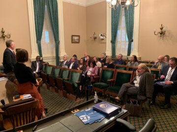 Members of Mobility 21 seated in a gallery listening to Authority staff during a presentation.